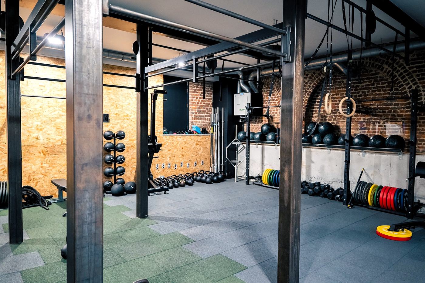 Salle Functional Fitness de Genly : espace industriel briques, kettlebells, anneaux et racks