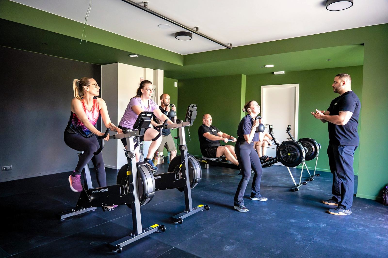 Coach accompagnant un membre — atmosphère personal training à Mons